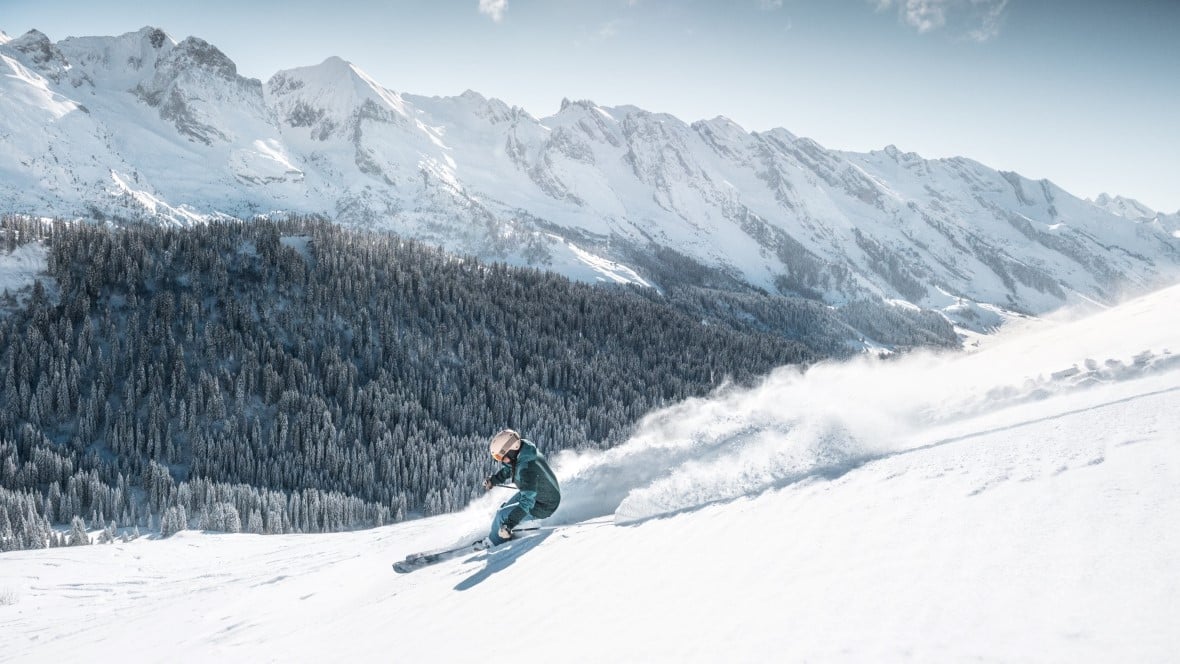 Skier on slope in Le Grand Bornand near La Clusaz with Aravis mountains in background