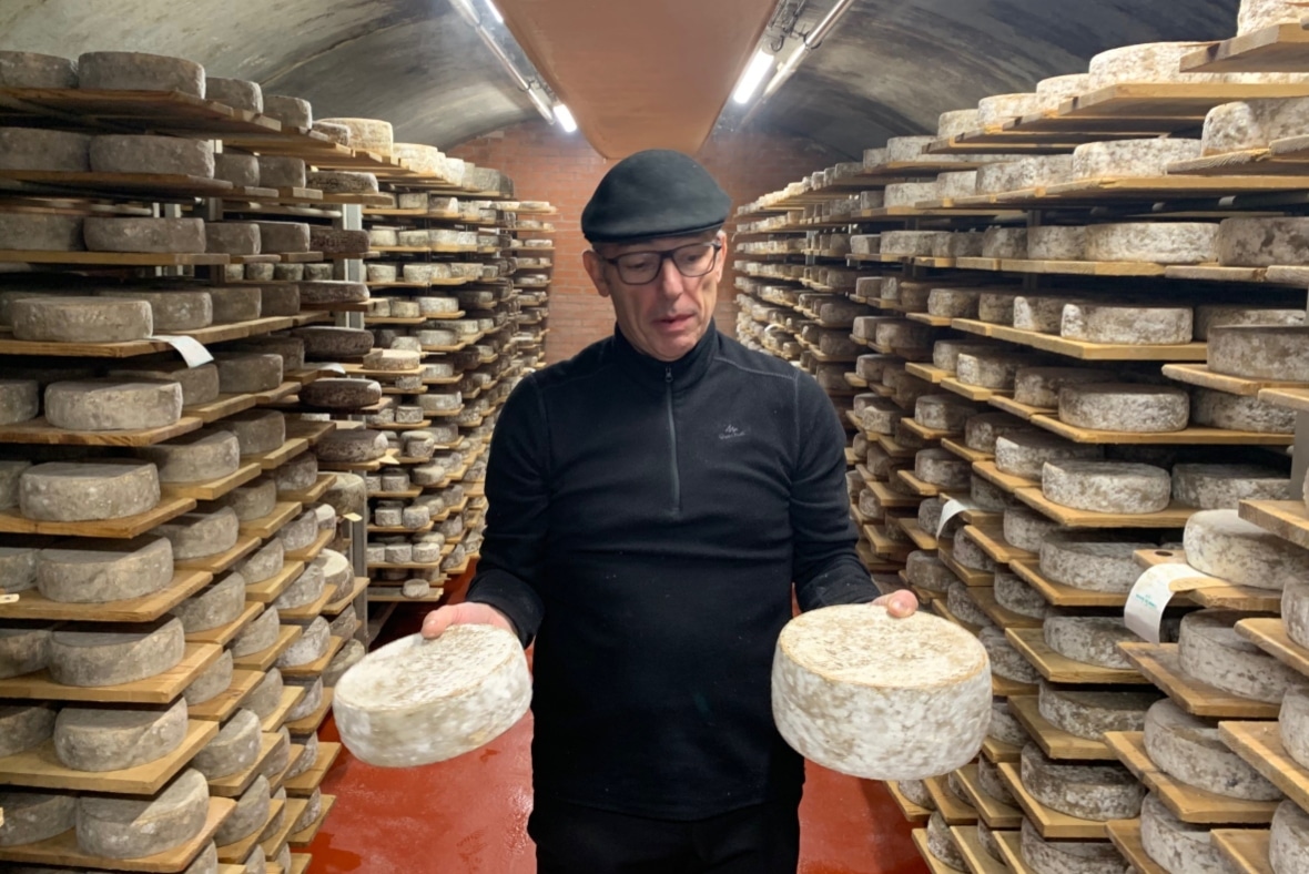 Joseph Pacard showing cheeses in the Paccard ripening cellar in Manigod near La Clusaz