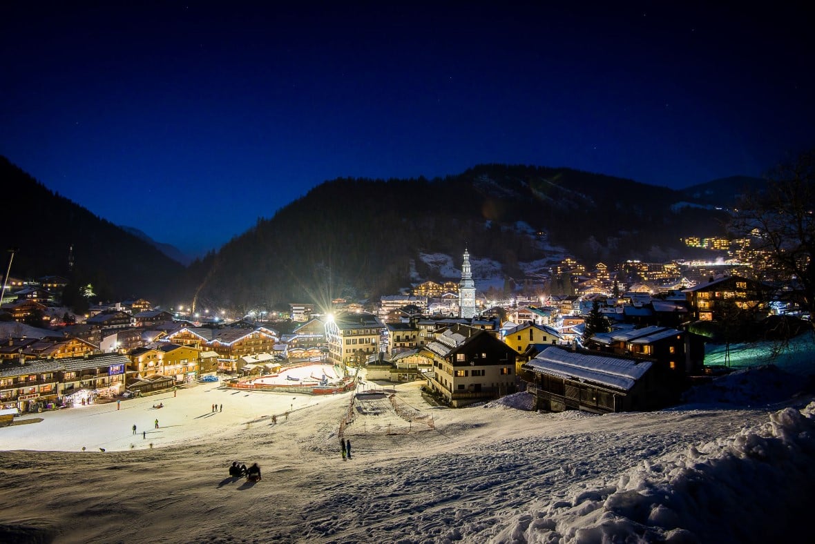 La Clusaz ski resort at night in winter seen from its surrounding ski slopes