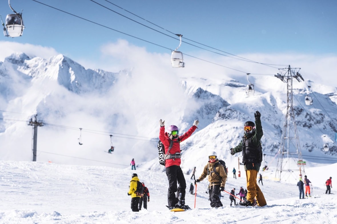 Skiers and snowboarders on the high altitude pistes above Les Deux Alpes