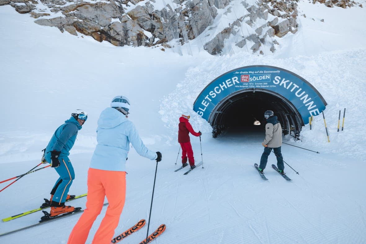 Skiers on glacier above Sölden skiing through ski tunnel